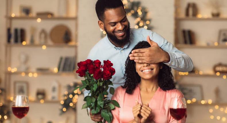 A romantic man giving her woman a flower